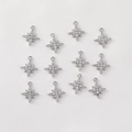 Macro shot of twelve silver eight-pointed star charms with micro-paved cubic zirconia - Silver Full Pave Star Burst Single Loop Style (H-71)