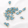 Macro detail of faceted teardrop crystal glass charms with golden metal edges - 1 Piece / Lake Blue