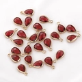 Macro view of teardrop red faceted glass charms with gold metal edges and hanging loops - 1 Piece / China Red