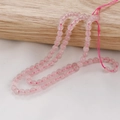 Close-up of pink rose quartz round beads with smooth surface on a light wood background - Rose Quartz (27#) / 4mm (Approx 92pcs/Strand)