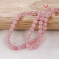 Macro shot of polished rose quartz beads showing natural ice crack texture and pink hue - Rose Quartz (28#) / 6mm (Approx. 60 Pieces/Strand)