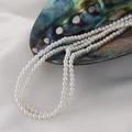 Lustrous white round pearl strand draped elegantly over a decorative abalone shell - 3mm Shell Bead (Approx 130 Pieces)