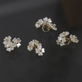 Close-up of mother of pearl four-leaf clover charms with gold beads on black background - Three Flower Cluster (17#) / 1 Piece