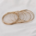 Close-up of stacked 14k gold-filled memory wire spring coils for DIY jewelry making - Gold Tone