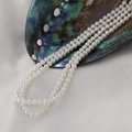 Elegant white shell pearl bead strands for DIY jewelry making displayed in a shell - 4mm Shell Bead (Approx 105 Pieces)