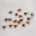 Macro shot of gold planet charms with red heart zircon for DIY jewelry making - Red