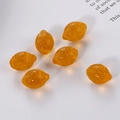 Detailed view of six translucent amber resin lemon charms with realistic skin texture - Bright Translucent Orange