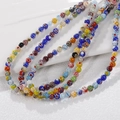 Dettaglio macro di perline colorate in vetro millefiori con motivi floreali per gioielli fai da te - Taglia Media (11#) / Multicolore