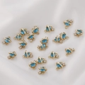 Saturn-shaped gold plated copper charm with blue cubic zirconia and ring hook - Lake Blue