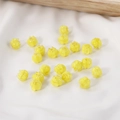 Close-up of lily of the valley glass flower beads on white fabric for DIY jewelry - 1 Piece / Yellow