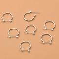 Orecchini a cerchio in argento lucido con chiusura a perno su sfondo rosa tenue - Piccolo / Argento