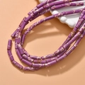 Nahaufnahme violetter zylindrischer Perlen mit Textur für DIY-Schmuckherstellung - Dunkellila