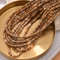 Detailed view of cylindrical natural stone beads in a gold tray for DIY jewelry making - Picture Jasper Style (34#)