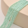 Macro shot of 2mm light green square crystal beads with matte finish for DIY jewelry making - Mint Porcelain