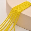 Close-up of 2mm square lemon yellow crystal glass beads for DIY jewelry making - Porcelain Yellow