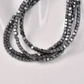 Macro detail of 3mm beveled square hematite beads with a dark metallic mirror finish - Gun Black Square
