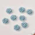 Macro shot of 12mm light blue resin rose charms for DIY jewelry and hair accessories - Cyan