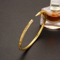 Elegante bracciale a polsino dorato con trama floreale e finitura in oro sabbiato - Bracciale Nezha