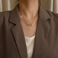 Elegante collana dorata con ciondolo numero 1111 indossata da una donna modello - Stile Numero 1111 (N1166—ST) / Colore acciaio