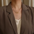 Collana in acciaio dorato con ciondolo numero 111 gotico indossata da una modella - Stile Numero 111 (N1167-GO) / Oro
