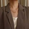 Collana dorata con ciondolo numero 333 gotico indossata da una modella elegante - Stile Numero 333 (N1169—GO) / Oro
