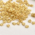 Close-up of gold-plated snowflake spacer beads with zircon for DIY jewelry making - 18K Gold Plated Snowflake Zirconia