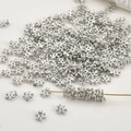 Close-up of 4mm silver snowflake spacer beads for DIY jewelry making and bead threading - White K Zircon Snowflake
