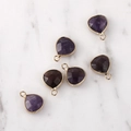 Macro view of five faceted purple crystal waterdrop pendants with gold metal edge - Gold Edged Amethyst