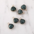 Close-up of five faceted dark green teardrop stone pendants with gold metal edging - Gold Edged Green Agate