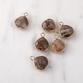Macro shot of faceted teardrop natural stone pendants with gold metal edge detailing - Gold Edged Mosaic Stone