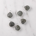 Detail of 6 teardrop labradorite stone pendants with silver metal edges on marble background - Silver Edged Labradorite