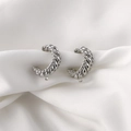 Detalle macro de pendientes en C trenzados plateados con aro para creación de joyas - Plateado