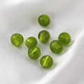 Macro shot of 8 translucent green glass beads with natural swirl textures on white silk - Round Beads / 5 Pieces / 17# Grass Green