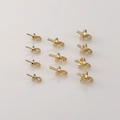 Close-up of 10 gold-plated peg bails for DIY pearl jewelry making projects - Light Gold Small