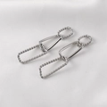 Silver geometric link chain earrings on white silk fabric with textured details - Silver
