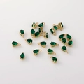 Vista macro de colgantes de circón verde en forma de pera bañados en oro de 14K para joyería DIY - Gota Esmeralda