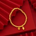 Dettaglio di ciondoli a loto in oro opaco e bocciolo su bracciale di perline - Bracciale Elastico Seme di Loto