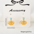 Detail of evil eye huggie earrings with orange enamel and cubic zirconia on card - Orange Enamel Style