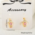 Golden hoop earrings with zircon stones and red evil eye enamel on white display - Red Style
