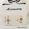 Golden micro-pave zircon evil eye hoop earrings on white accessory card - Black and White Style
