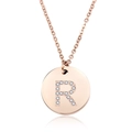 Dettaglio di un ciondolo tondo in oro rosa con lettera R scintillante in diamanti - Lettera R