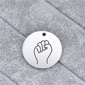Close-up of a silver stainless steel round pendant with engraved hand gesture sign - Fist Gesture (AL335)
