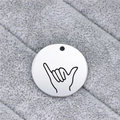 Close-up of polished silver steel round tag with black engraved Shaka gesture line art - Shaka Gesture (AL338)