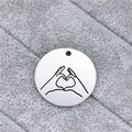 Macro detail of polished stainless steel round pendant with heart gesture engraving - Finger Heart Gesture (AL341)