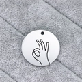 Macro close-up of polished stainless steel round tag featuring a black OK hand gesture - OK Gesture (AL342)