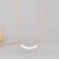 Elegant gold-plated necklace with nine natural freshwater pearls in a curved pendant design - 18K Gold