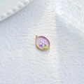 Detalle de un colgante ovalado dorado con esmalte morado y detalles de flores - Flor Ovalada Púrpura (TZ-TP1087-02-purple)