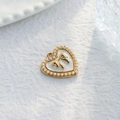 Dettaglio di un ciondolo a cuore con fiocco dorato e perle bianche su fondo bianco - Ciondolo Bordo Perla Cuore Fiocco Oro (TZ-TP1085-02-white)