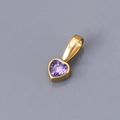 Detailed macro view of heart-shaped gold-plated pendant with purple cubic zirconia stone - June