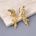 Dettaglio macro degli orecchini dorati a forma di ala su superficie in pietra - Oro 18K